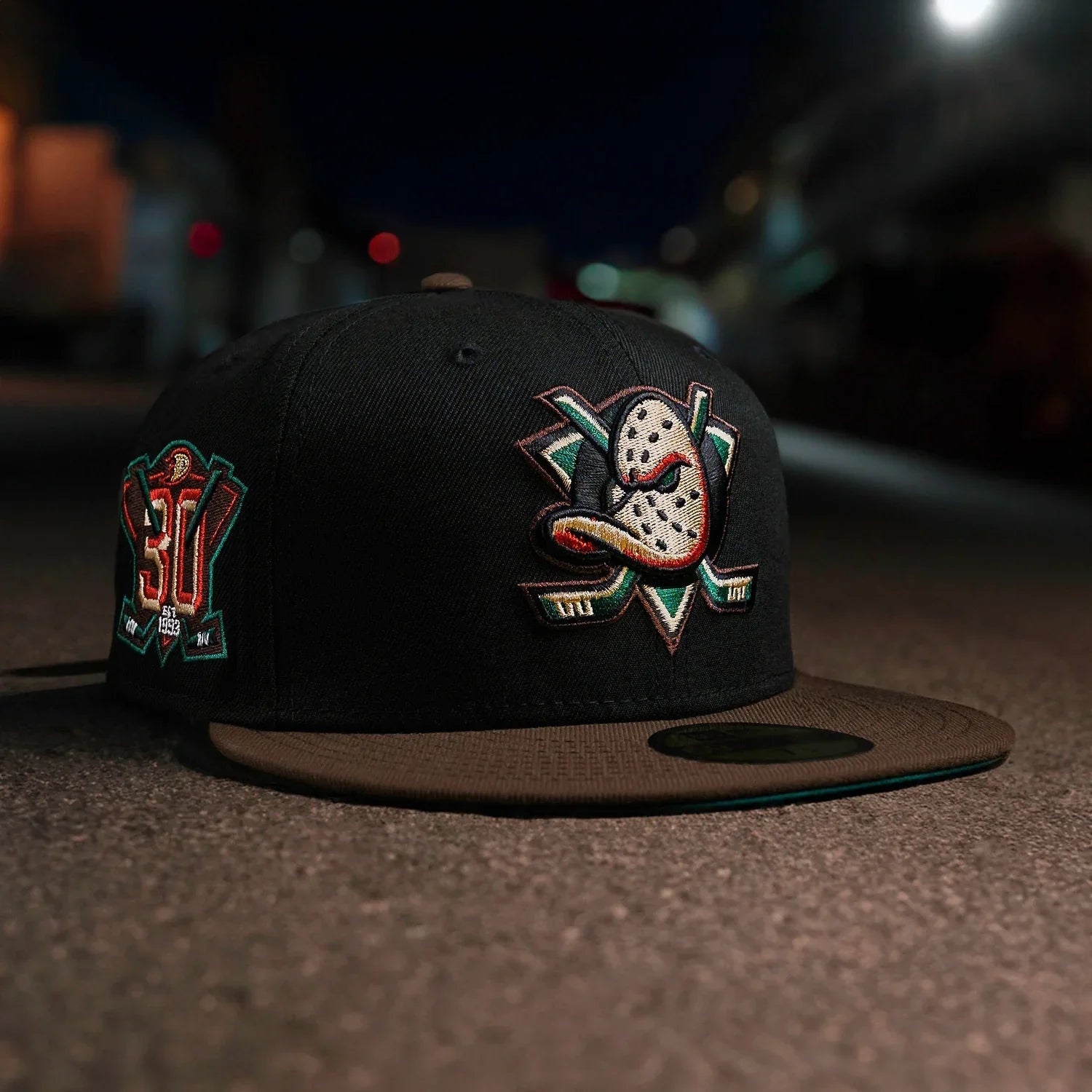 Black cap with embroidered logos on a dark surface