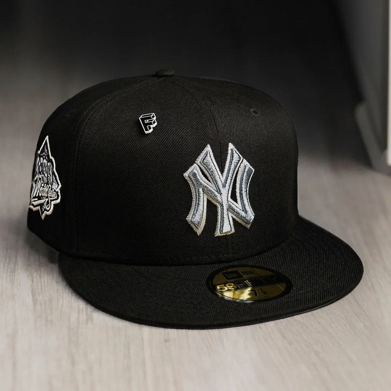 Black baseball cap with a logo on a wooden surface