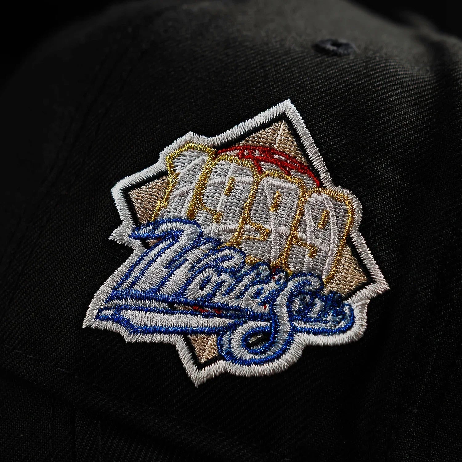 Black cap with a colorful embroidered logo on a dark background