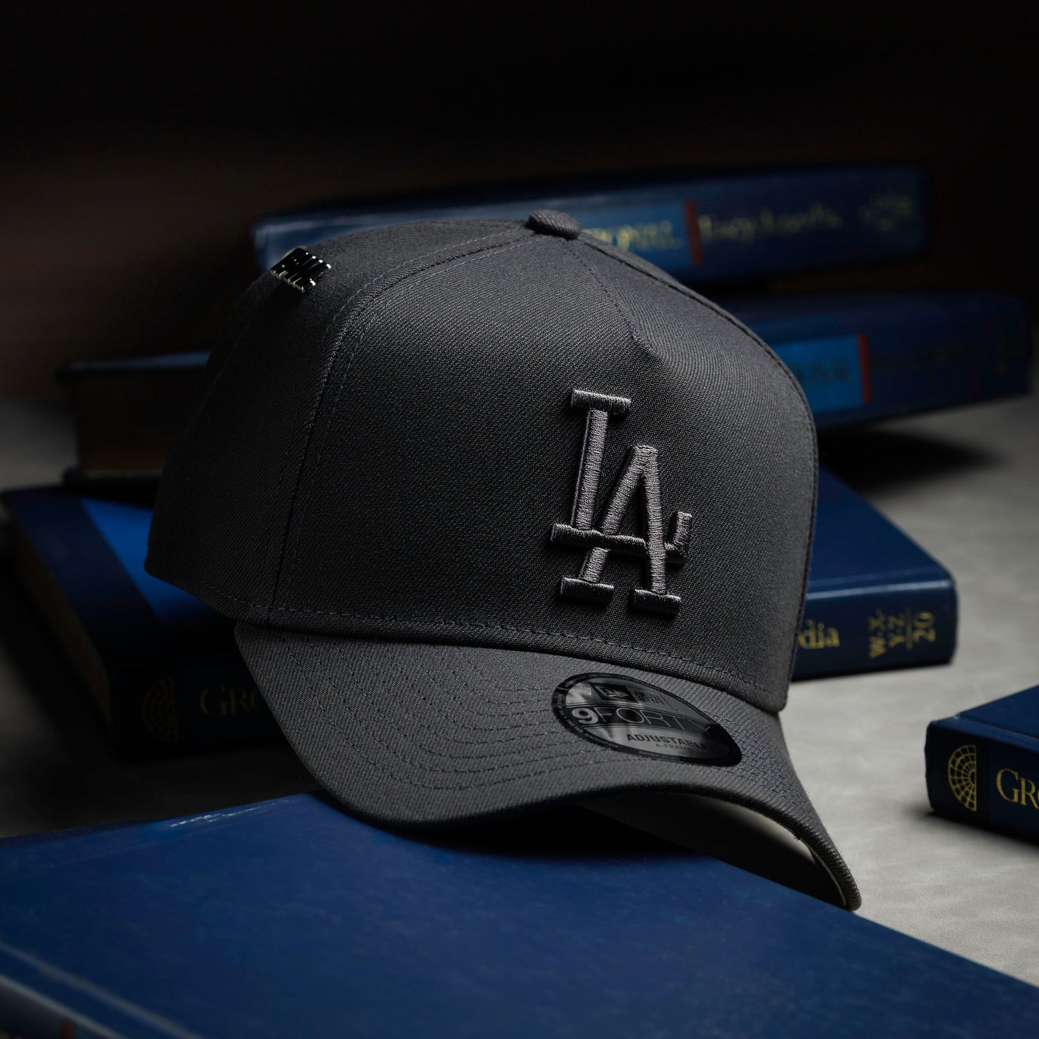 Black cap with a logo on a stack of books