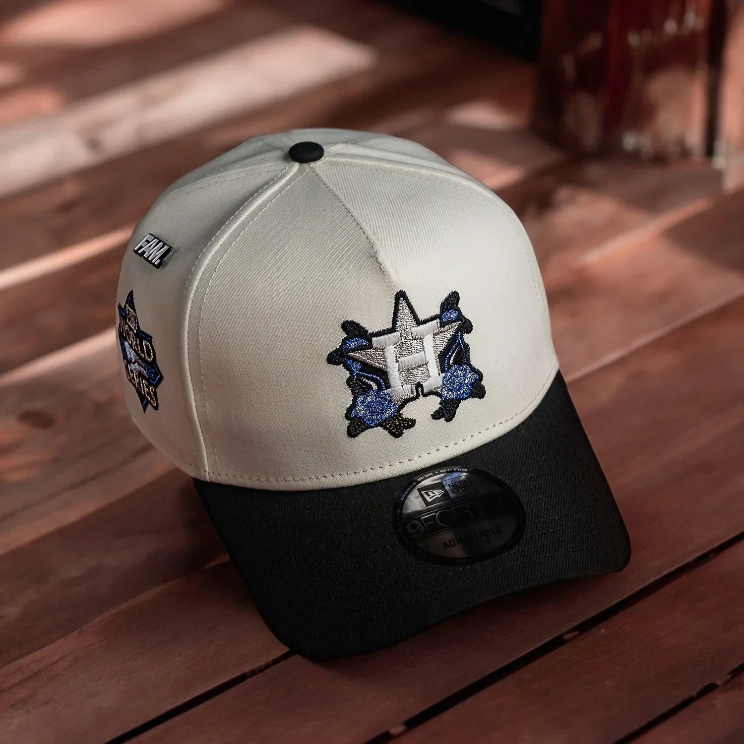 Two-tone cap with embroidered logo on a wooden surface