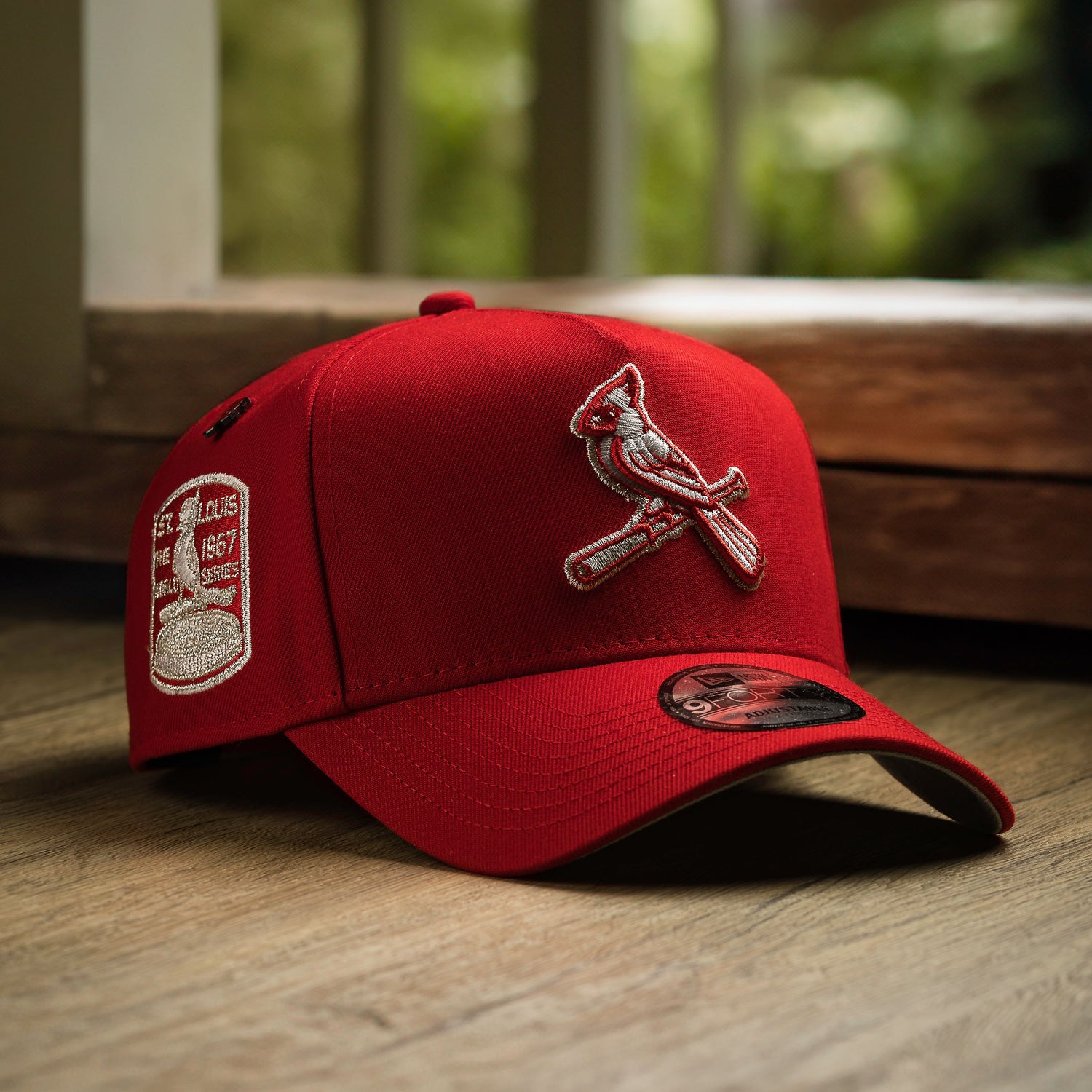 Red baseball cap with a logo on a wooden surface