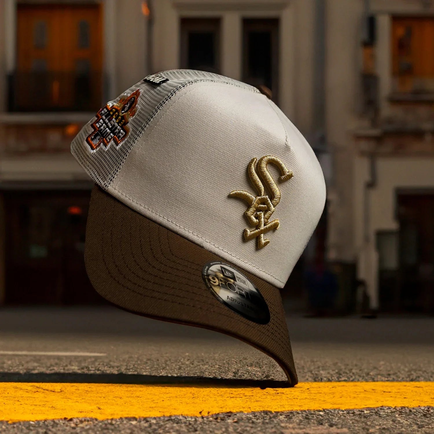 Beige and brown cap with embroidered logo on a blurred street background