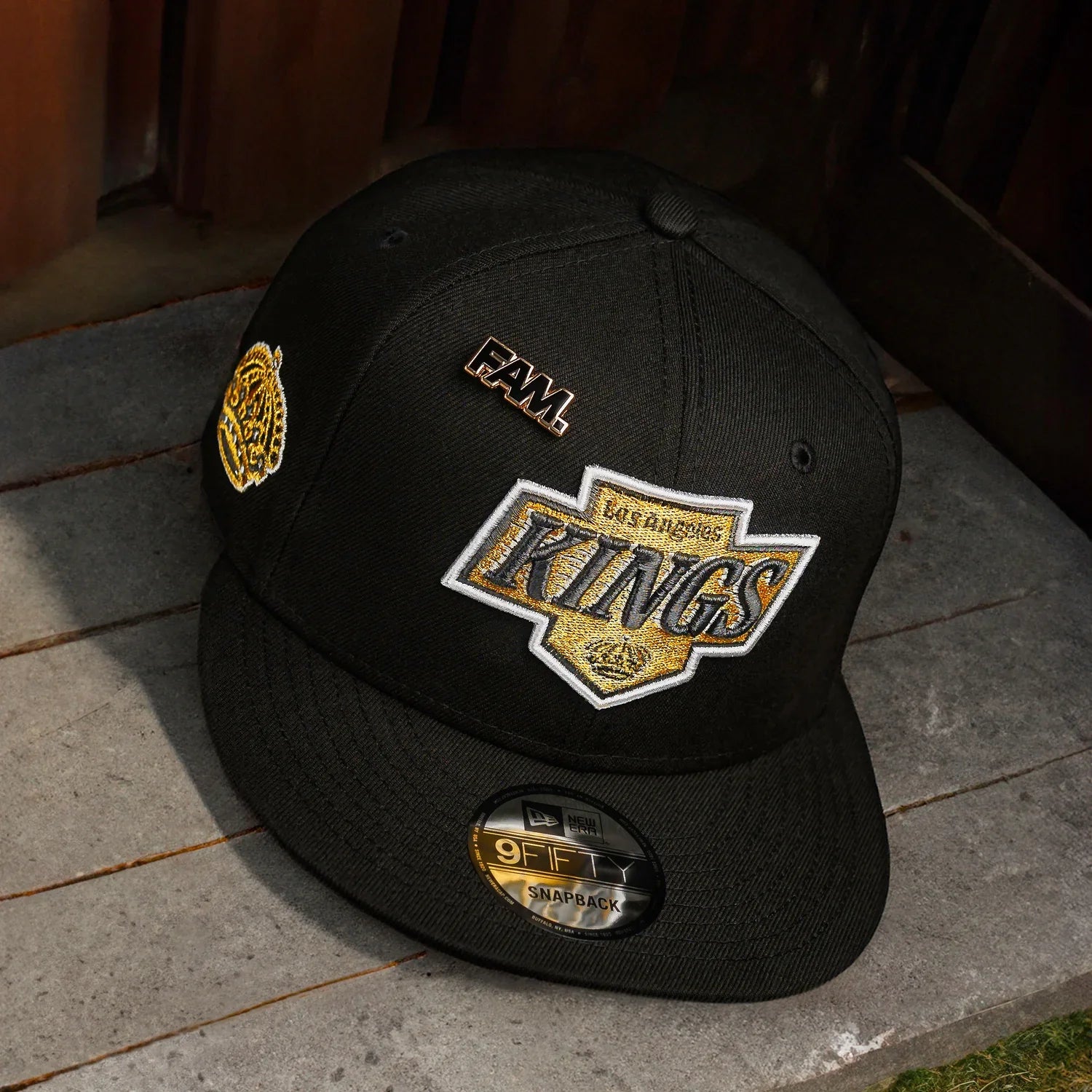 Black cap with 'Los Angeles Kings' logo and patches on a wooden surface