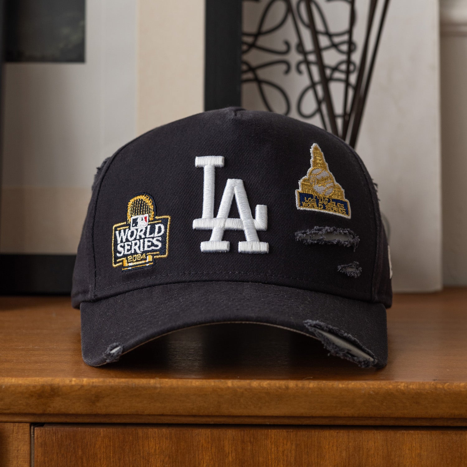Black cap with LA Dodgers logo and patches on a wooden surface