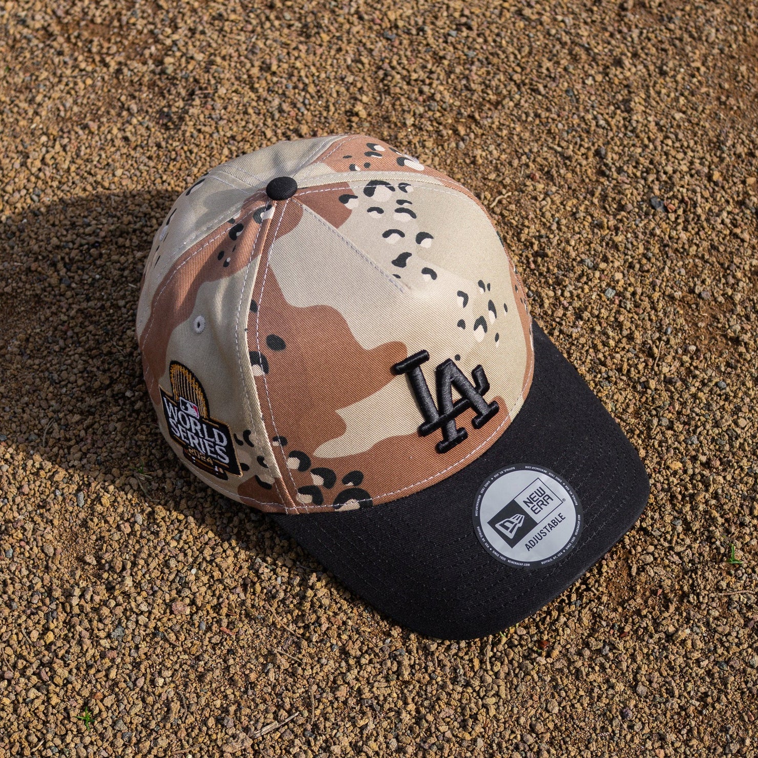 Camouflage baseball cap with LA Dodgers logo on a textured surface